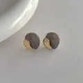 Dettaglio degli orecchini irregolari in resina grigia e metallo dorato con perno S925 - Grigio