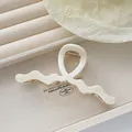 Detail of cream wavy acetate hair claw clip with strong gold metal spring mechanism - Off White