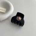 Detail of matte black claw clip with a brown pearl accent in a silver metal frame - Brown Pearl Style