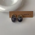 Dettaglio degli orecchini a goccia in resina con bordo dorato e trama a inchiostro - Grigio