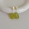 Dettaglio di orecchini vintage con pendenti in resina verde e finitura in metallo dorato - Verde