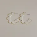 Detail of bohemian raffia weave C-shape gold earrings with delicate floral fan texture - White