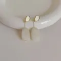 Dettaglio macro di orecchini retrò in resina con smalto crema e argento s925 lucido - Bianco avorio
