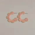 Macro detail of pink raffia woven flower C-hoop earrings with gold bead accents - Pink