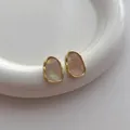 Detailansicht der unregelmäßigen Goldlegierung-Ohrringe mit rosa schillernder Acryl-Einlage - Weiß