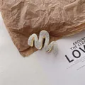 Detailed view of a wavy hair claw clip featuring silver glitter finish and gold metal teeth - Quicksand Silver