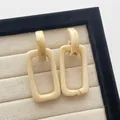 Detail van geometrische hars oorbellen met crème marmeren textuur op beige fluweel - Rechthoekige Druppel (F25 Beige) / Beige (F25 Beige)