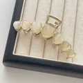 Elegant gold metal hair claw clip featuring seven heart-shaped opal stones for women - Gold Heart Cat Eye