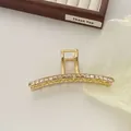 Dettaglio della molletta per capelli dorata con zirconi champagne su vassoio in legno - Stile Barra Dritta (R25)