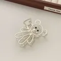 Close-up of matte silver bear hair claw clip with heart detail on a wooden jewelry tray - Silver (R12)