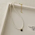 Detail of pearl necklace with red heart pendant on a beige tray in soft lighting - Heart Pendant Pearl Necklace