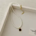 Detail of red agate pendant with gold border on a classic white pearl necklace chain - Square Pendant Pearl Necklace