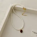 Detail of red agate pendant with gold bezel on a white pearl strand necklace - Oval Pendant Pearl Necklace