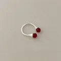 Detailed view of silver open ring featuring vibrant red agate beads on linen fabric - Red Agate