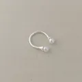 Close-up of a silver open ring featuring two white pearls on a soft beige fabric background - Pearl Ring