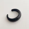 Detail view of a minimalist black resin C-shaped open cuff bracelet with glossy finish - Cuff Bracelet / Black