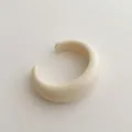 Detailed macro view of a creamy white resin open C-ring cuff with smooth polished finish - Cuff Bracelet / Off White
