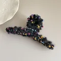 Close-up of black plush hair claw clip with colorful yarn balls and gold silk thread - Black Mixed Straight