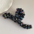 Detail of black plush hair claw with colorful yarn and gold thread texture on beige surface - Black Mixed S-Shape