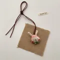 Close-up of handmade cloth rabbit pendant with pink strawberry fabric and jute base - Red Cheeks Rabbit (T56)