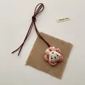 Close-up of handmade white fabric bunny pendant with pink floral base on linen - Pink Pentagram Rabbit (T46)
