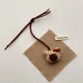 Detail of a handmade brown bear charm with yellow checkered fabric and a brown bow tie - Orange Yellow Grid Bear
