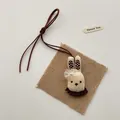 Detail of a handmade fabric rabbit doll pendant with mesh bow and brown cord - Bowknot Rabbit (T55)
