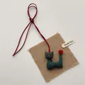 Detail of handmade green fabric cat charm with orange pompom and gold bell accessory - Green Bell Cat