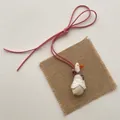 Detailed view of a handmade cream plush duck pendant with lace shawl and pink cord - White Lace Little Duck (T05)