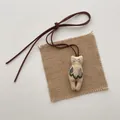 Detail of handmade embroidered cat fabric pendant with floral pattern and suede lanyard - Beige Mustache Cat