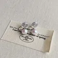 Makroaufnahme von Perlen-Clip-Ohrringen mit lila Glanz und Silikon-Komfortpolstern - 8mm Clip / Irisierendes Weiß