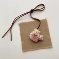 Detailed close-up of a handmade fabric cartoon fish pendant with red embroidery details - Pink Goldfish