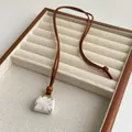 Vintage lange ketting met wit marmeren tas hanger aan een bruin lederen koord - Howliet