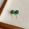 Makro-Detail von eleganten grünen Achatperlen-Ohrsteckern mit polierten Goldmetallstiften - Grün (Größe 10)