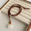 Detail of tiger eye stone pendant on brown leather cord necklace with wood bead - White Crystal Style