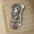 Detailed macro view of the silver abstract face brooch with a high-polished mirror finish - Silver