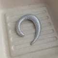 Dettaglio ravvicinato della spilla a U irregolare color argento con finitura in metallo martellato - Stile A Forma Di U Martellato / Argento
