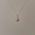 Makroaufnahme eines rosa Perlenanhängers in tropfenförmigem Goldrahmen mit Diamanten - Rosa Wassertropfen Perlenhalskette