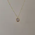 Detail of a gold satellite chain necklace with a hammer-textured shell pendant - Gold Hammered Round Necklace