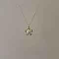 Detail of a minimalist gold flower pendant with a central freshwater pearl on a thin chain - Gold Five-Petal Flower Pearl Necklace
