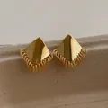Close-up of golden geometric stud earrings with layered metallic chain fringe tassels - Gold (E13)