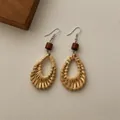 Macro detail of bohemian woven rattan teardrop earrings with a brown wood bead and metal hook - Wood Bead Rattan Teardrop (B350)