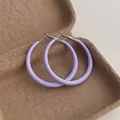 Close-up of lilac purple oversized matte hoop earrings on a textured paper box - Large Circle / Purple