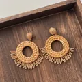Macro view of woven raffia hoop earrings with bohemian fringed texture on wood - Hollow Round Half Circle Tassel Wood Color (A310)