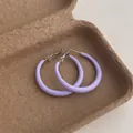 Detailed view of lavender purple matte hoop earrings on natural pulp tray background - Small Circle / Purple