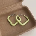 Detail of light green square geometric hoop earrings resting in a kraft gift box - Square Small / Cyan