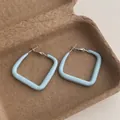 Detail view of light blue square lacquer earrings on a textured brown eco-friendly tray - Square Small / Blue