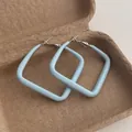 Detail of square light blue geometric hoop earrings with a matte lacquer finish in a gift box - Large Square / Blue