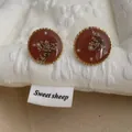 Detailed macro view of vintage resin earrings with dried flowers and tiny white pearls - Dried Flower Pearl Style / Caramel color