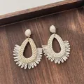 Detail of handmade raffia drop earrings with fringe texture on a natural wooden tray - Teardrop Half Circle Tassel Beige (A302)